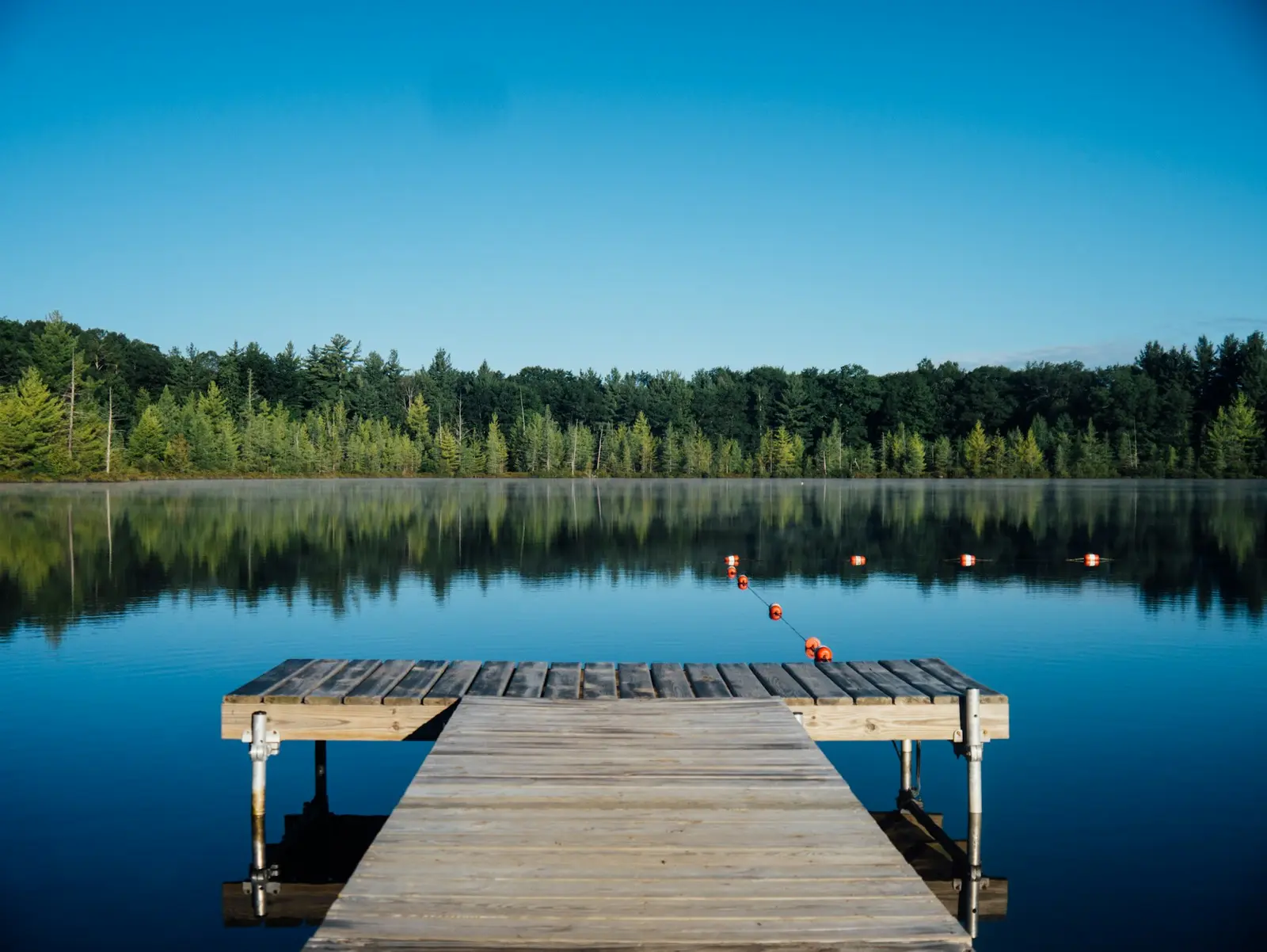 Web design in Rainbow Falls, Chestermere, Alberta — a wooden dock on a calm prairie lake at the edge of the city under an open Alberta sky